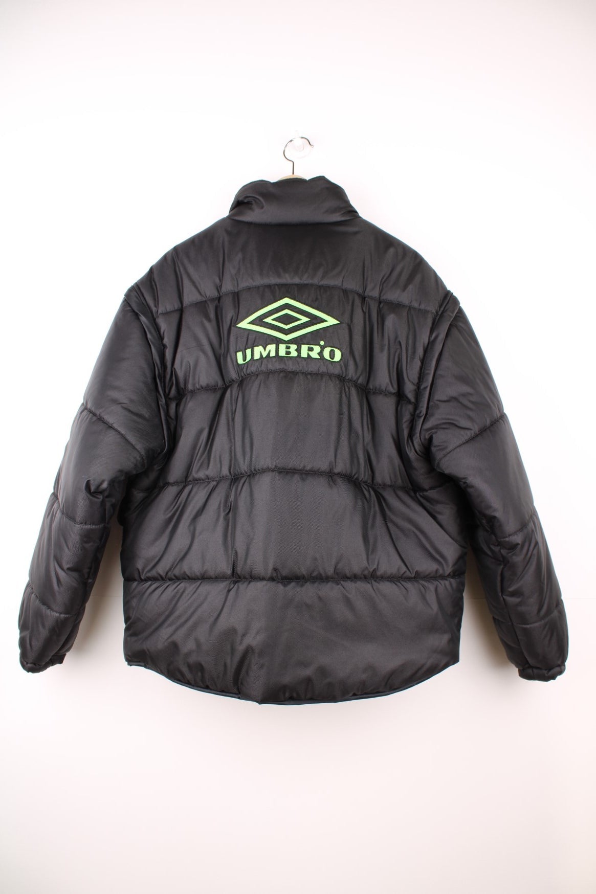 Umbro Pro Training Puffer Coat with detachable sleeves to turn into a gilet, black colourway with neon green logos embroidered on the front, back and sleeve.