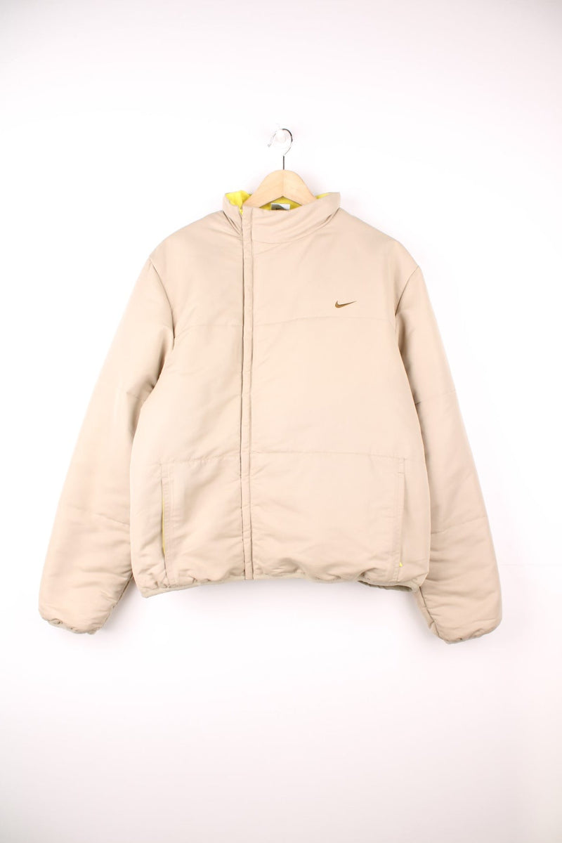 Nike Puffer Coat in a tanned colourway, zip up with side pockets, and has the swoosh logo embroidered on the front. 