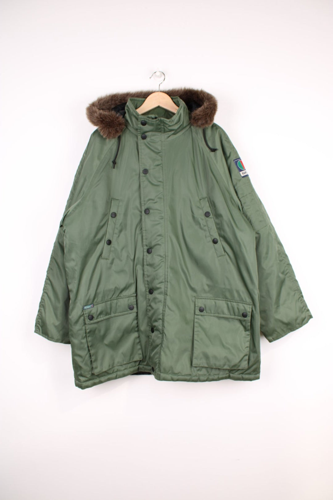 Kickers Parka Coat in a khaki green colourway, zip up with multiple pockets, insulated with a quilted lining, has a detachable hood with a faux fur lining, and has the logo embroidered on the front and on the left sleeve.