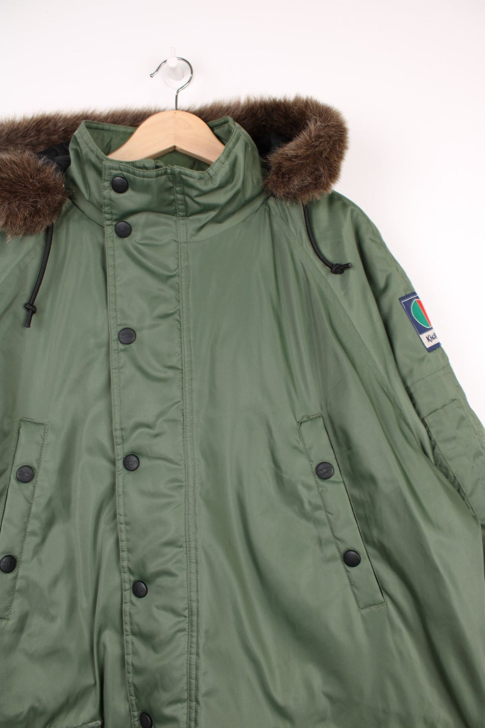 Kickers Parka Coat in a khaki green colourway, zip up with multiple pockets, insulated with a quilted lining, has a detachable hood with a faux fur lining, and has the logo embroidered on the front and on the left sleeve.