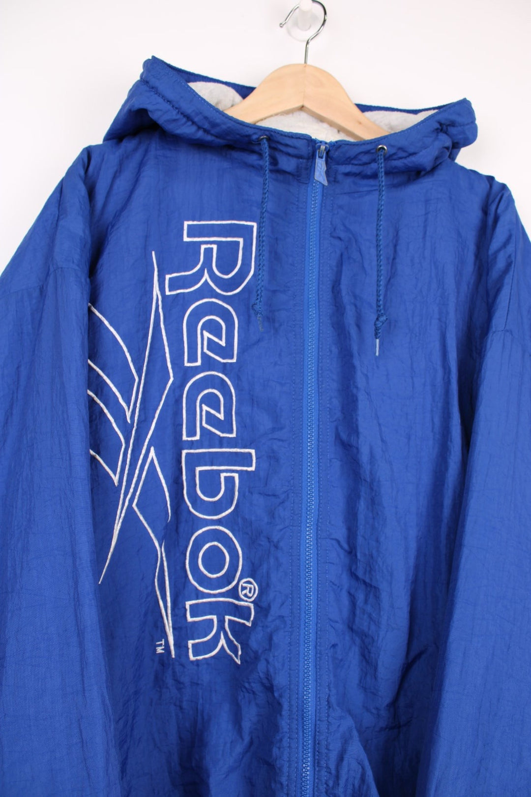 Reebok Jacket in a blue colourway, zip up with side pockets, insulated with a heavy cotton lining, hooded, and has the spell out logo embroidered down the front. 