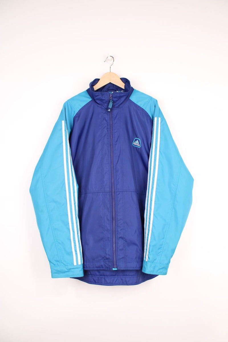 Adidas Training Jacket in a blue colourway with the iconic three stripes going down the sleeves, zip up with side pockets, and has the logo embroidered on the front. 