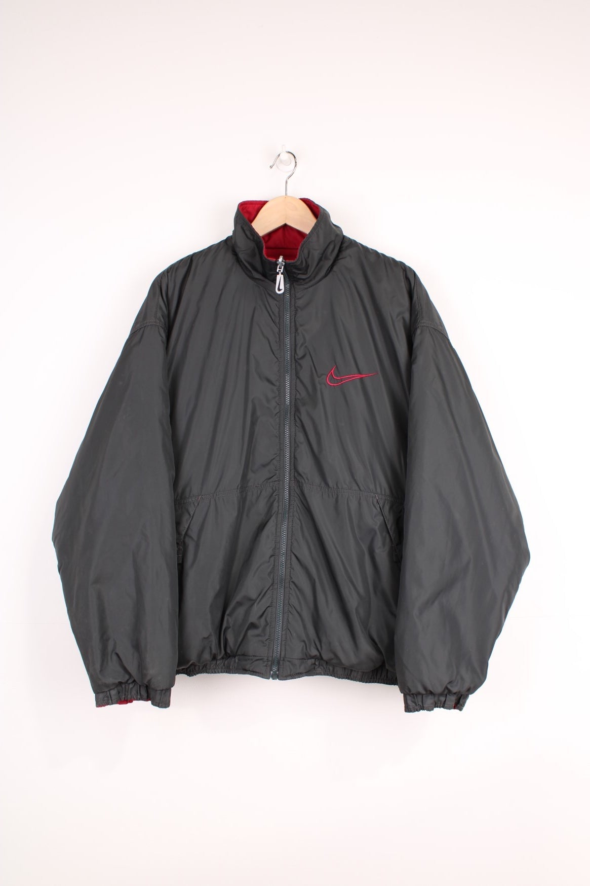 Nike Reversible Coach Jacket in either a black or burgundy colourway options, zip up with side pockets, and has the swoosh logo embroidered on the front.