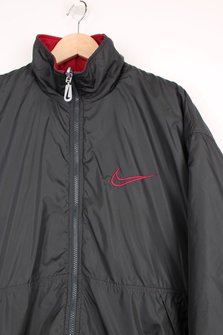 Nike Reversible Coach Jacket in either a black or burgundy colourway options, zip up with side pockets, and has the swoosh logo embroidered on the front.