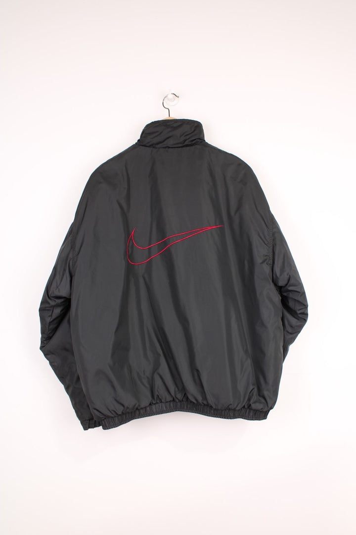 Nike Reversible Coach Jacket in either a black or burgundy colourway options, zip up with side pockets, and has the swoosh logo embroidered on the front.