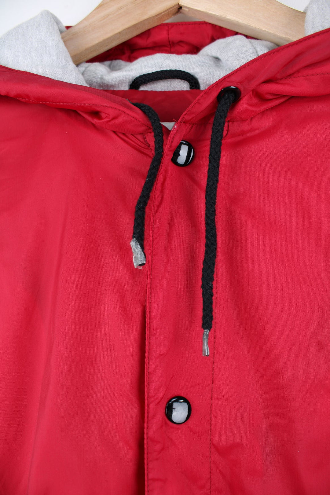 Red Nike coat with popper fastenings. Features embroidered logo on the chest and back. 