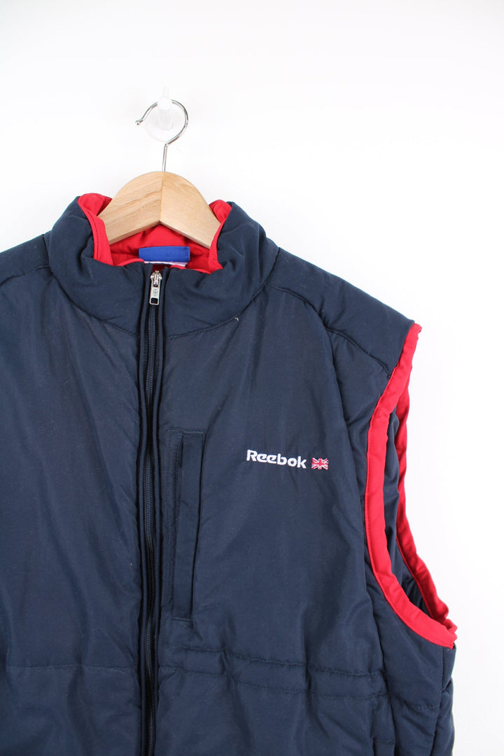 Reebok Classic blue and red gilet featuring embroidered logo on the chest and printed logo across the back.