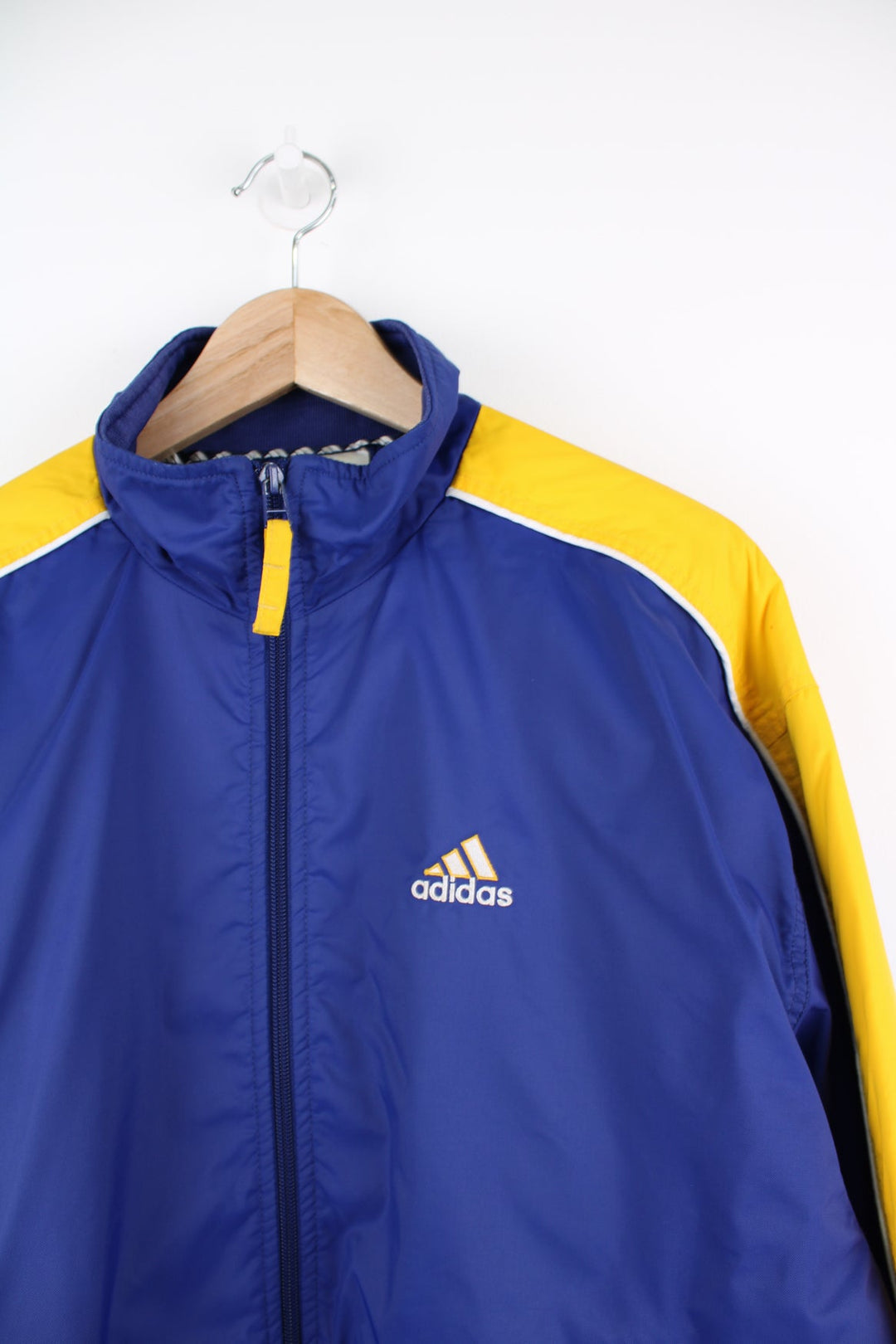 Vintage Adidas bomber style jacket in blue and yellow. Features embroidered logo on the chest.