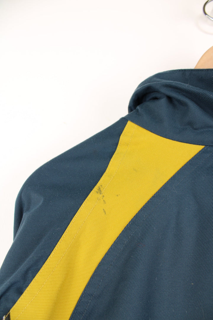 Vintage Adidas coat in blue and yellow. Features embroidered logo.