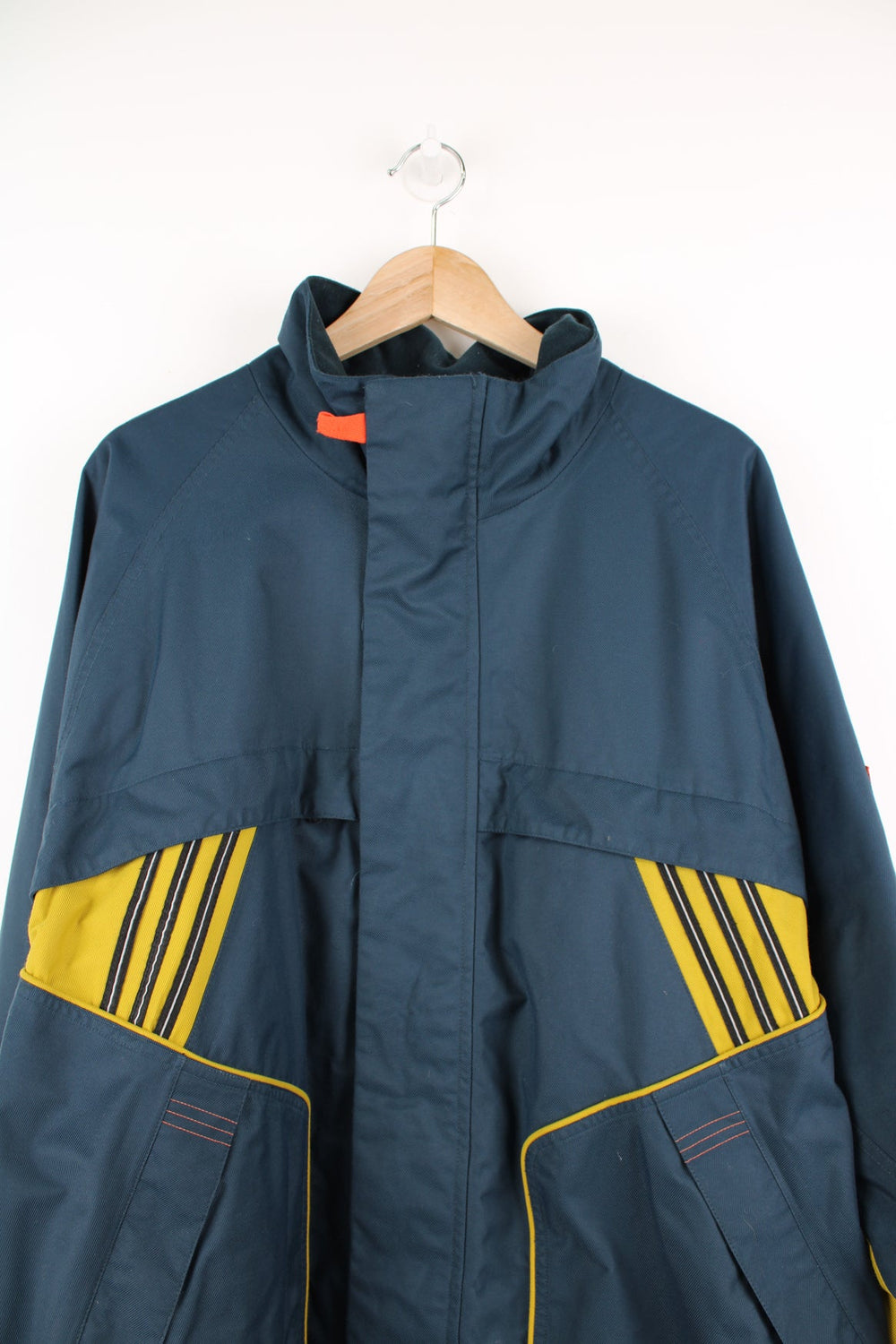 Vintage Adidas coat in blue and yellow. Features embroidered logo.