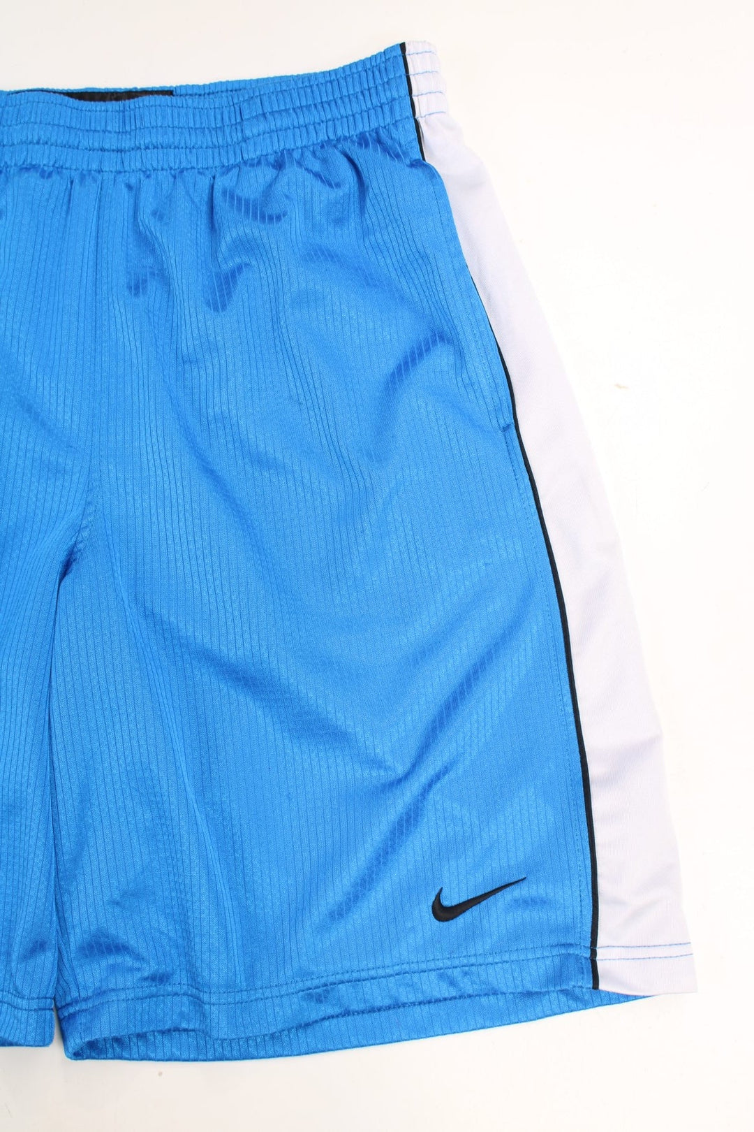 Nike Basketball Shorts in a blue and white colourway with stripes going down the sides, has an adjustable waist, side pockets, and has the swoosh logo embroidered on the front.