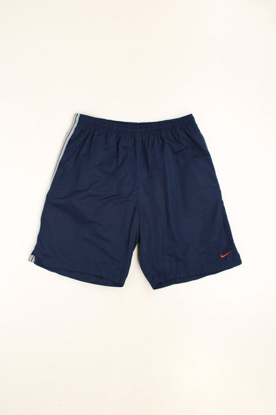 Nike Shorts in a blue colourway with grey stripes going down the sides, has an adjustable waist, pockets, and the swoosh logo embroidered on the front. 