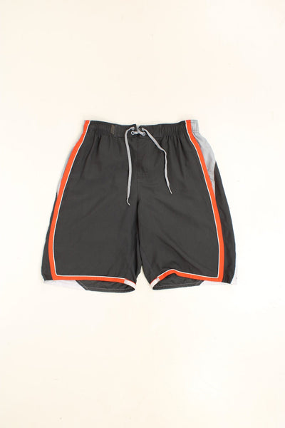 Nike Shorts in a grey, orange and white colourway with stripes going around the back and sides, has an ajdustable waist, side pockets, netted lining, and the logo embroidered on the back. 