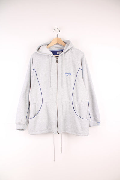 Reebok Lightweight Hoodie in a grey colourway with blue stripes going down the sides, zip up with side pockets, hooded, adjustable waist, and has the logo embroidered on the front and left sleeve. 