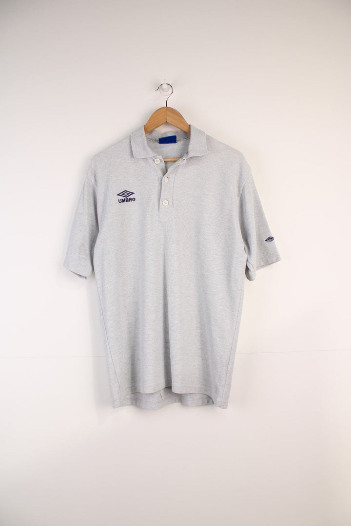 Umbro Polo Shirt in a grey colourway, button up and has the logo embroidered on the front. 