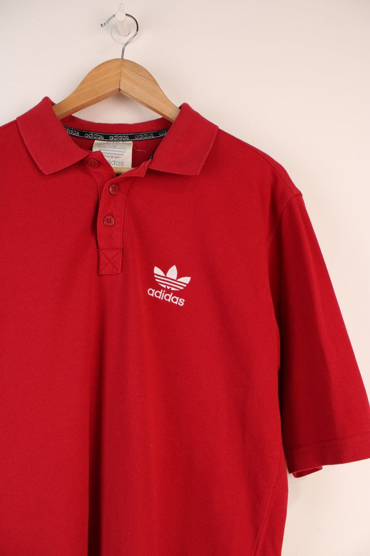 Adidas Polo Shirt in a red colourway, button up and has the logo embroidered on the front. 