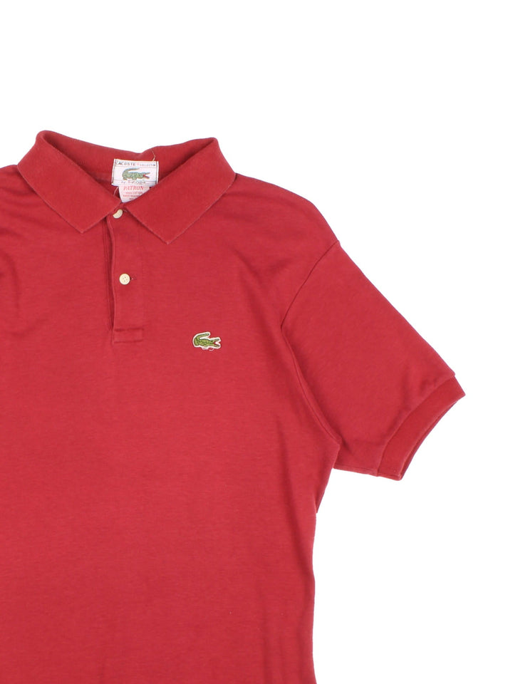 Vintage Lacoste by Izod Polo Shirt in a red colourway with button up collar and the logo embroidered on the front.