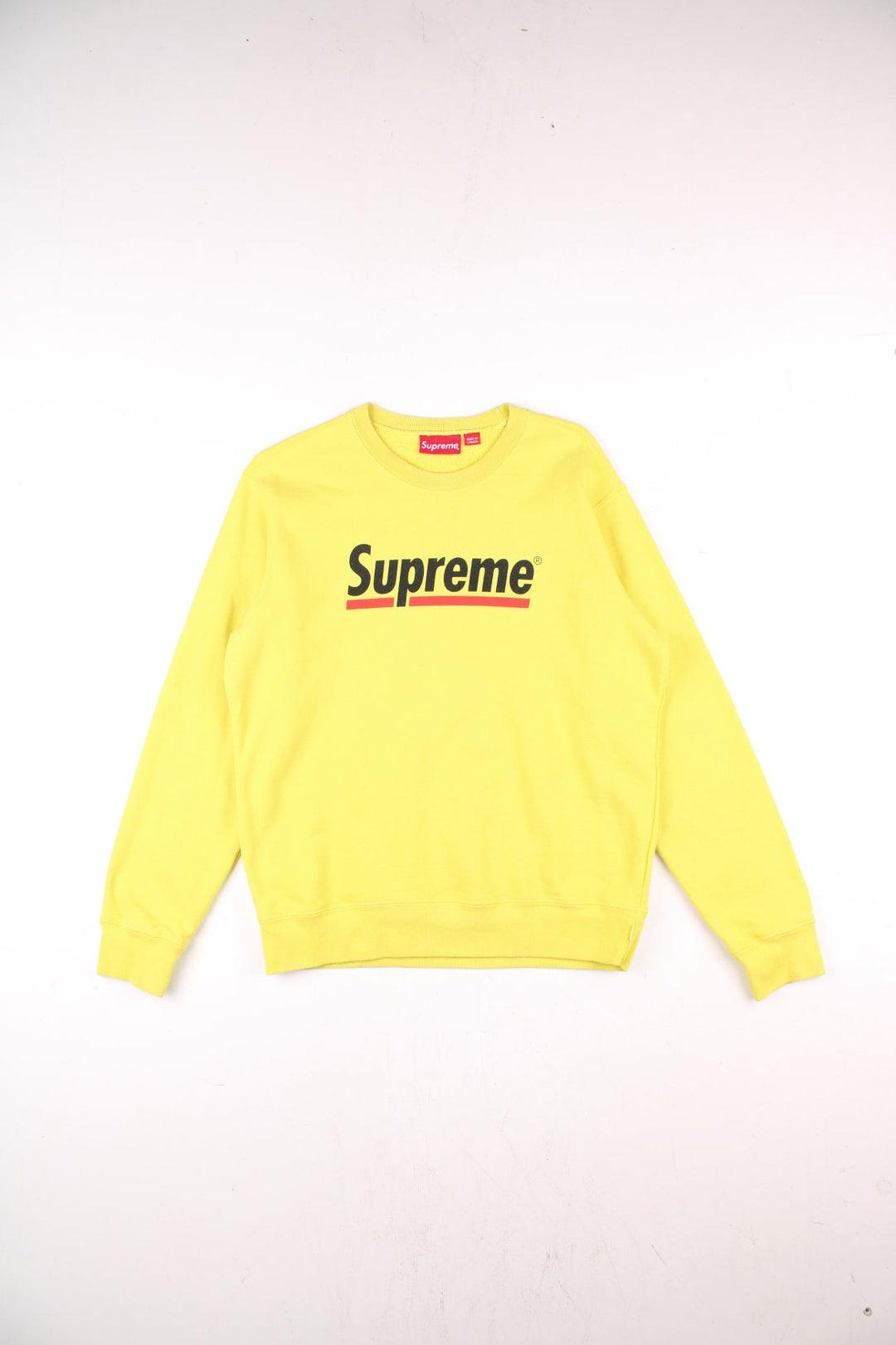 Supreme Underline sweatshirt in yellow with a printed spellout in black and red on the front.