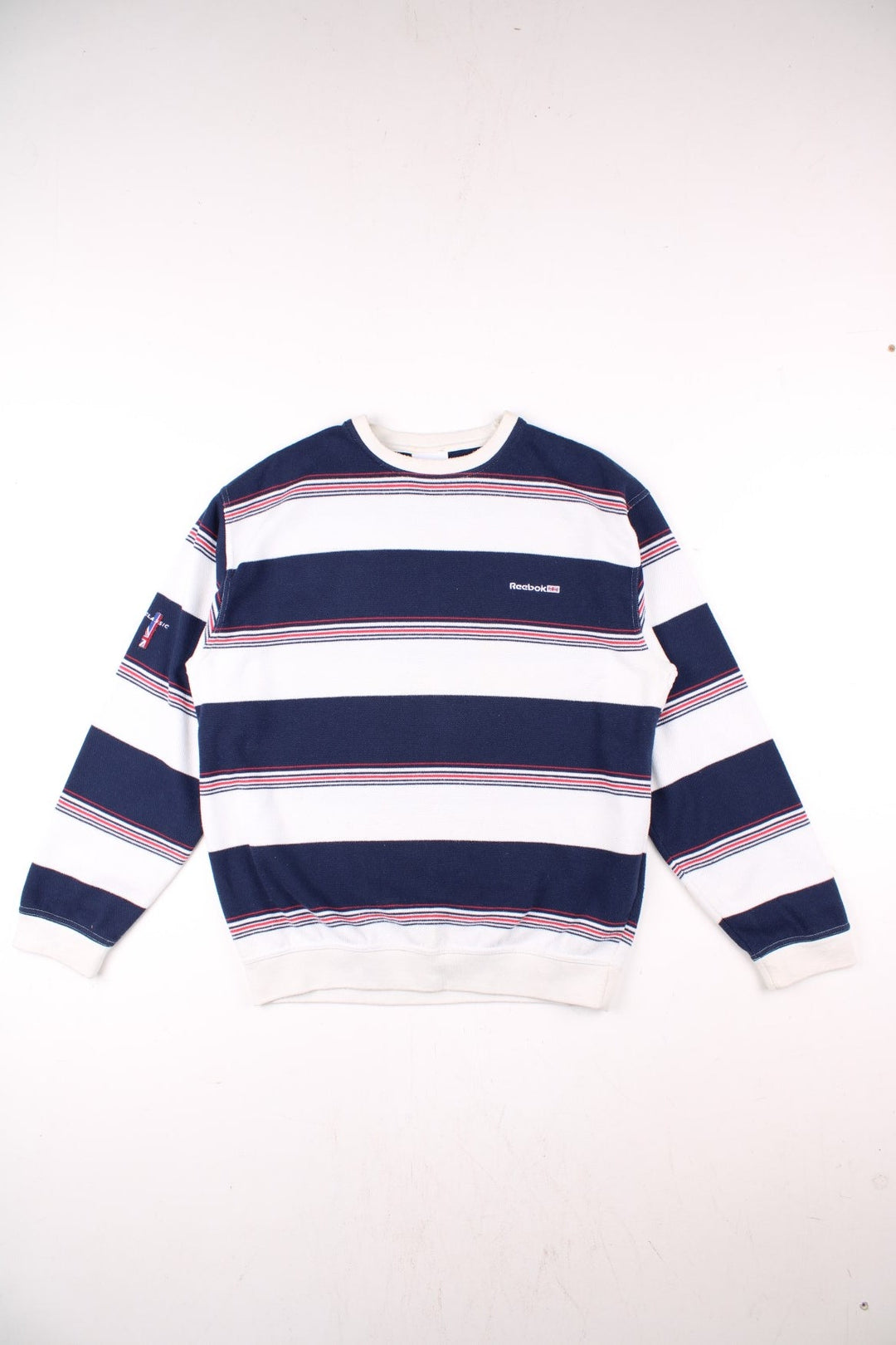 Reebok raglan sleeve sweatshirt in blue, white, and red stripes with a small embroidered logo on the chest.