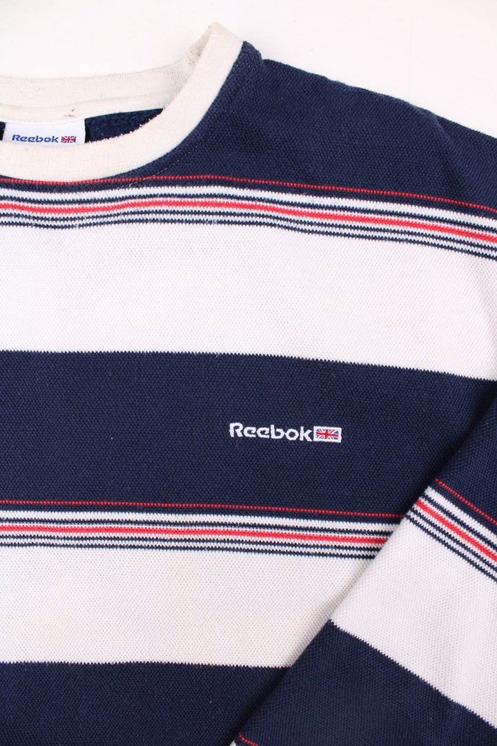 Reebok raglan sleeve sweatshirt in blue, white, and red stripes with a small embroidered logo on the chest.