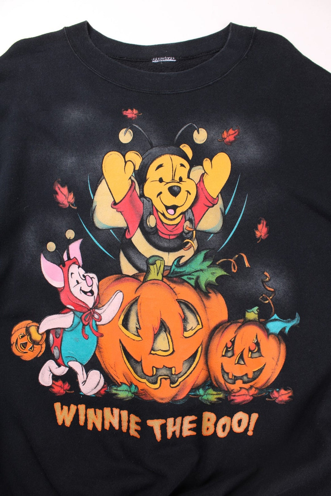 Disney Winnie the Pooh Halloween themed sweatshirt in black with large graphic of Winnie and Piglet in costrume with pumpkins and text reading 'Winnie the Boo!'.