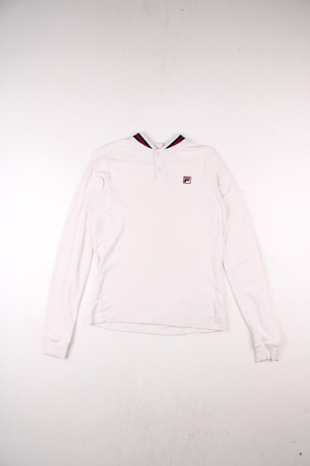 Vintage Fila white line polo shirt in white with two buttons at the neck, blue and red stripe details at the collar, and an F logo on the chest.