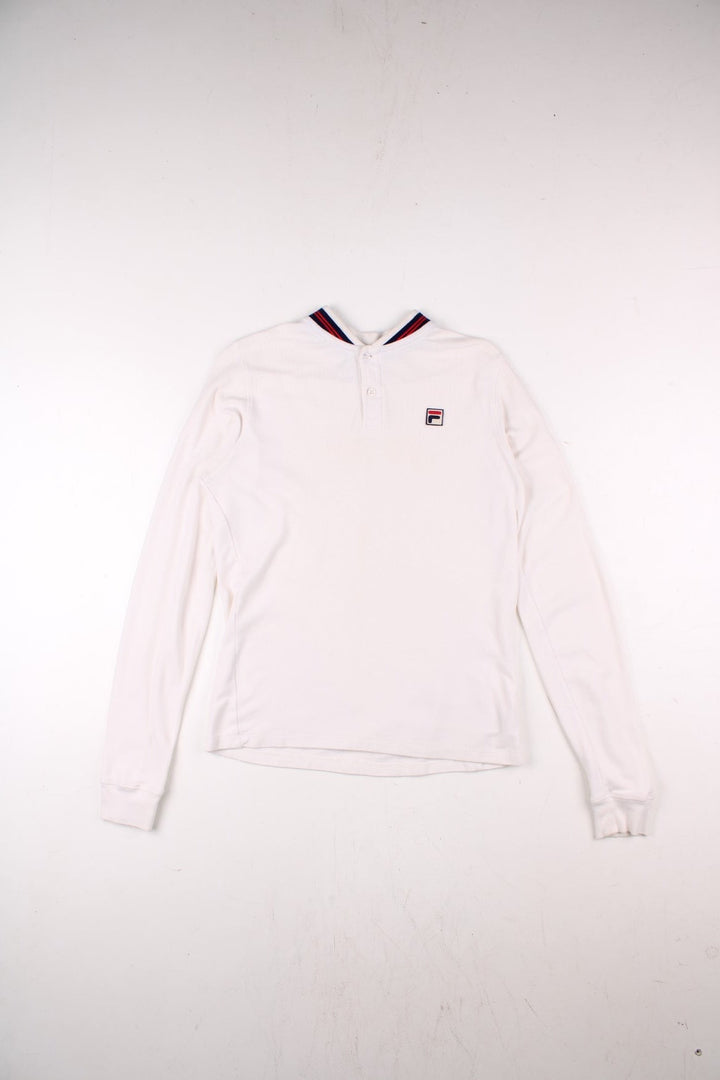 Vintage Fila white line polo shirt in white with two buttons at the neck, blue and red stripe details at the collar, and an F logo on the chest.