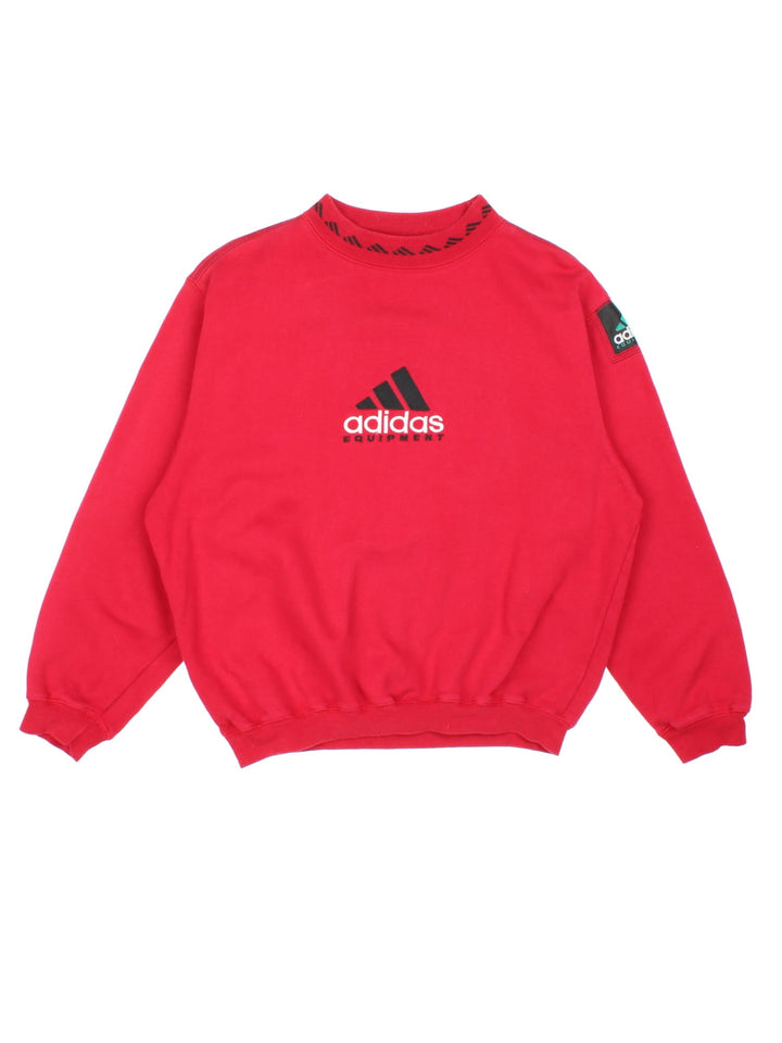 Vintage 1990s Adidas Sweatshirt in a red colourway with the logo embroidered on the front and centre. There is also an Adidas equipment patch sewn onto the sleeve. The sweatshirt has an elasticated graphic printed collar. 