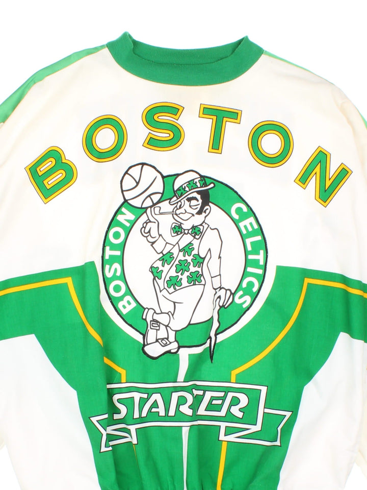 Vintage 1990s Starter Boston Celtics NBA Sweatshirt in a white and green colourway. The sweatshirt has a large graphic on the front, and back with a satin stripe down the arms and an embroidered starter patch on the sleeve. Features elasticated cuffs and hem and also has two side pockets. 