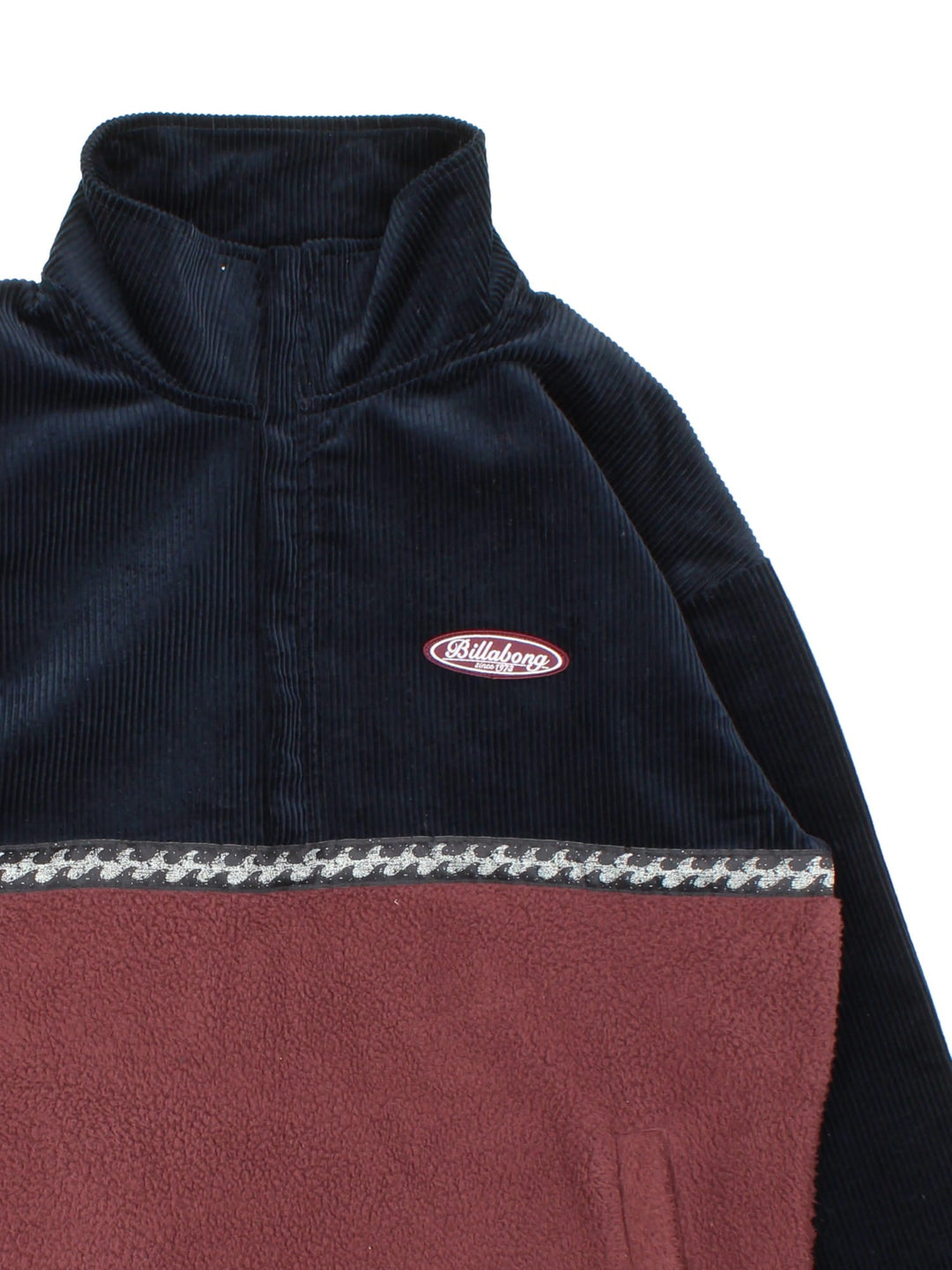 Billabong 1/4 Zip fleece in a navy blue and burgundy colourway. The fleece has a corduroy top half, also features a small logo stitched on the front and two zipable front pockets. 