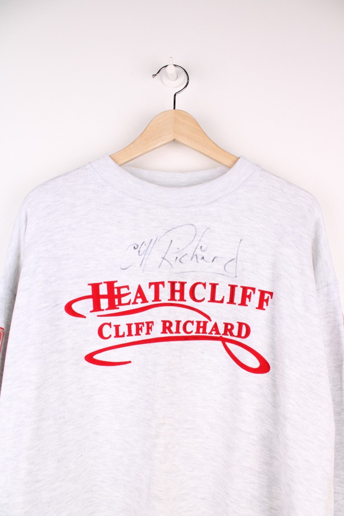 1996/97 signed Cliff Richard Heathcliff musical UK tour sweatshirt in grey marl with red embroidered text and shiny patches on the sleeves listing the tour cities and dates. 