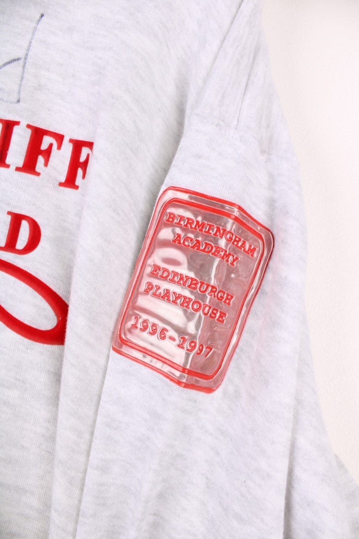 1996/97 signed Cliff Richard Heathcliff musical UK tour sweatshirt in grey marl with red embroidered text and shiny patches on the sleeves listing the tour cities and dates. 