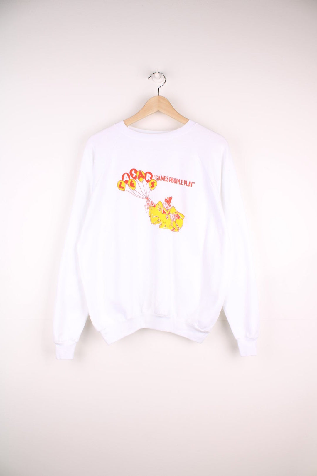 Caesar's 'Games People Play' graphic sweatshirt in white with a clown holding balloons in red and yellow. 