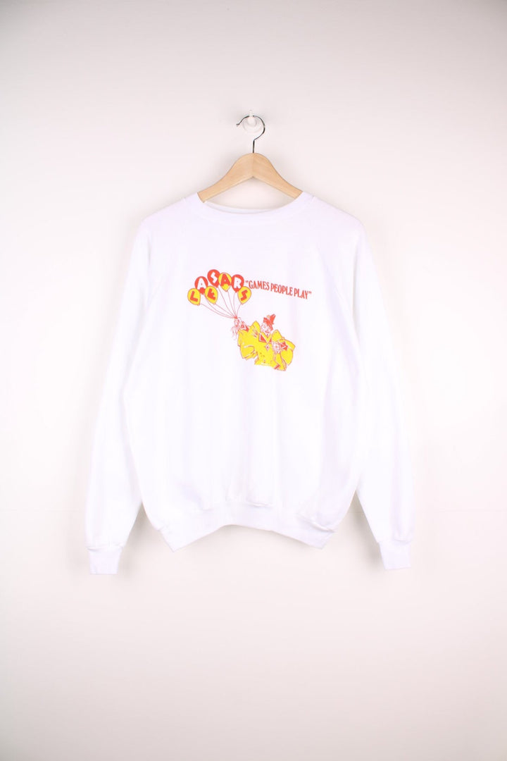 Caesar's 'Games People Play' graphic sweatshirt in white with a clown holding balloons in red and yellow. 