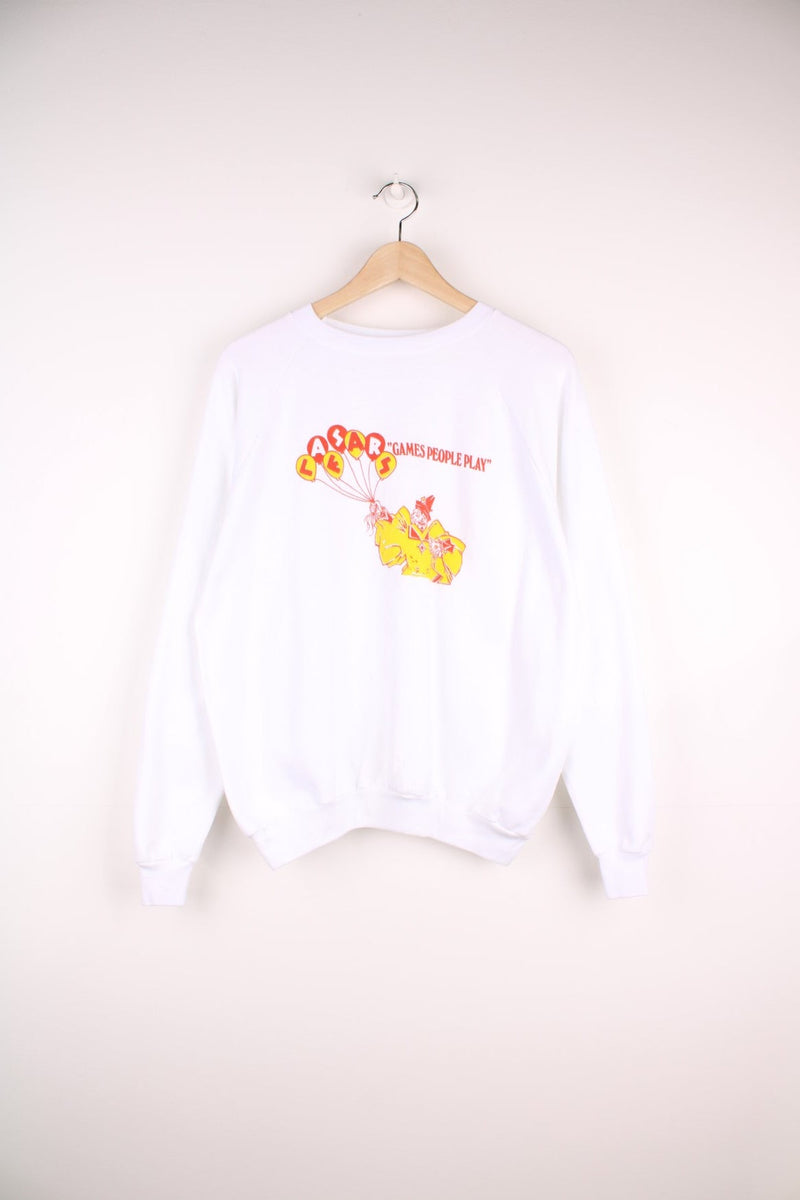 Caesar's 'Games People Play' graphic sweatshirt in white with a clown holding balloons in red and yellow. 