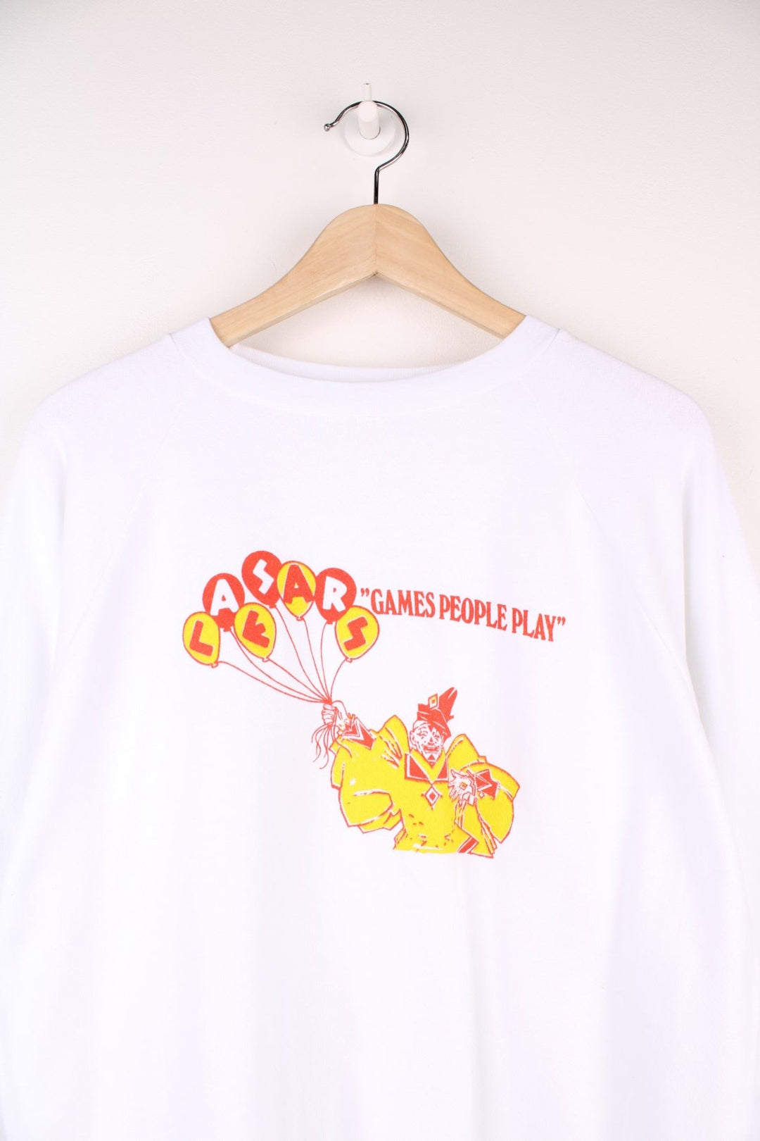 Caesar's 'Games People Play' graphic sweatshirt in white with a clown holding balloons in red and yellow. 