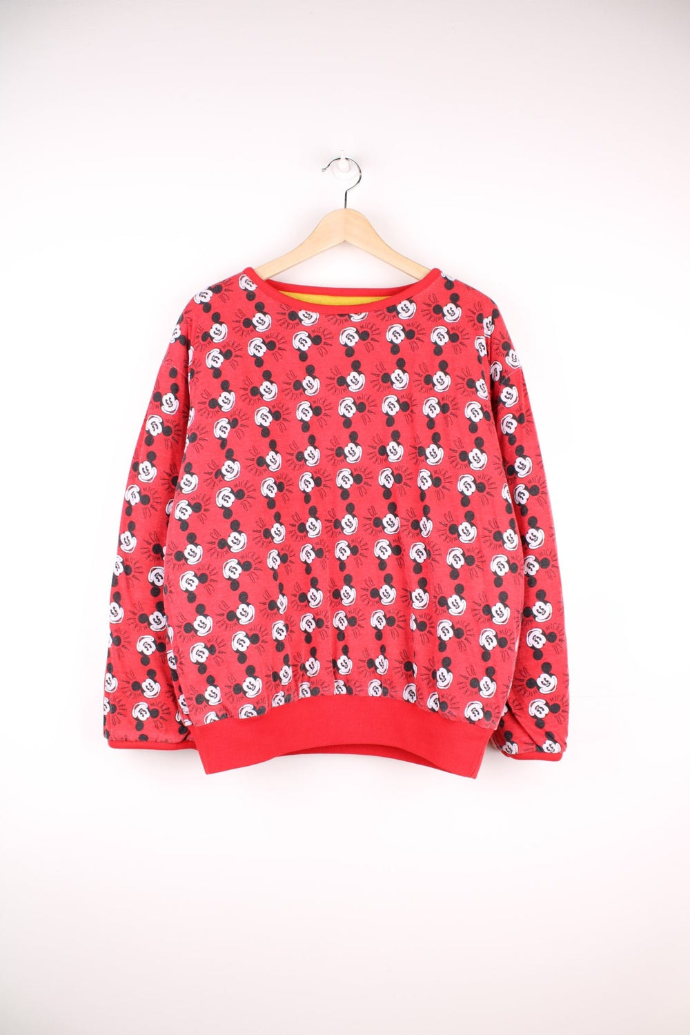 80s/90s Disney reversible lined sweatshirt with one red, yellow, and blue colourblocking side featuring a large Mickey Mouse graphic and text reading 'Mickey and Co.', and one red side with a repeating Mickey head pattern. 