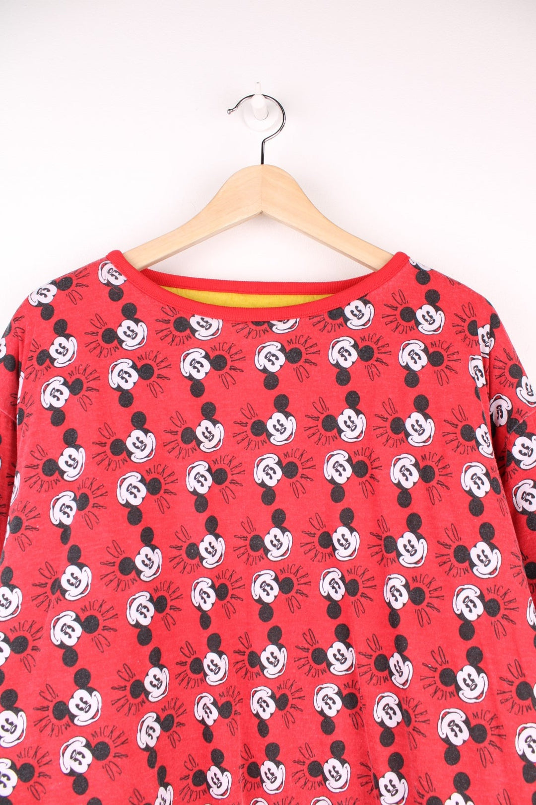 80s/90s Disney reversible lined sweatshirt with one red, yellow, and blue colourblocking side featuring a large Mickey Mouse graphic and text reading 'Mickey and Co.', and one red side with a repeating Mickey head pattern. 