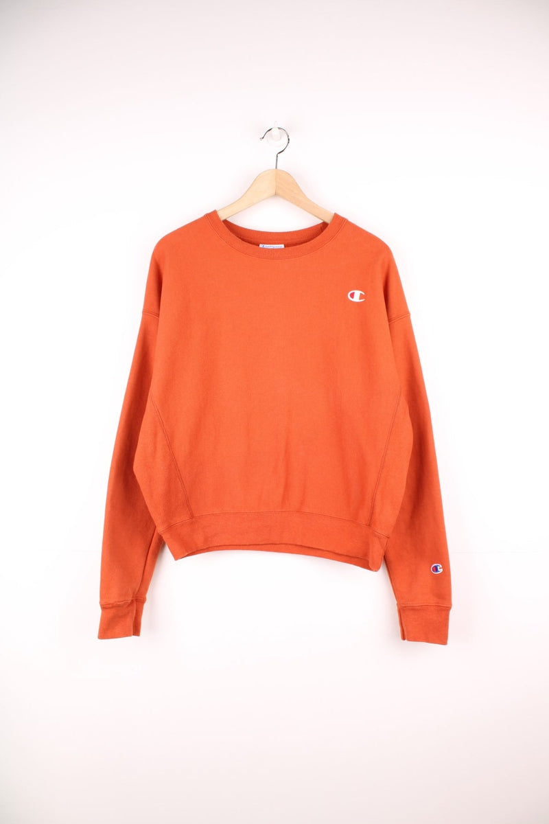 Champion Reverse Weave orange sweatshirt with embroidered logo on the chest. 