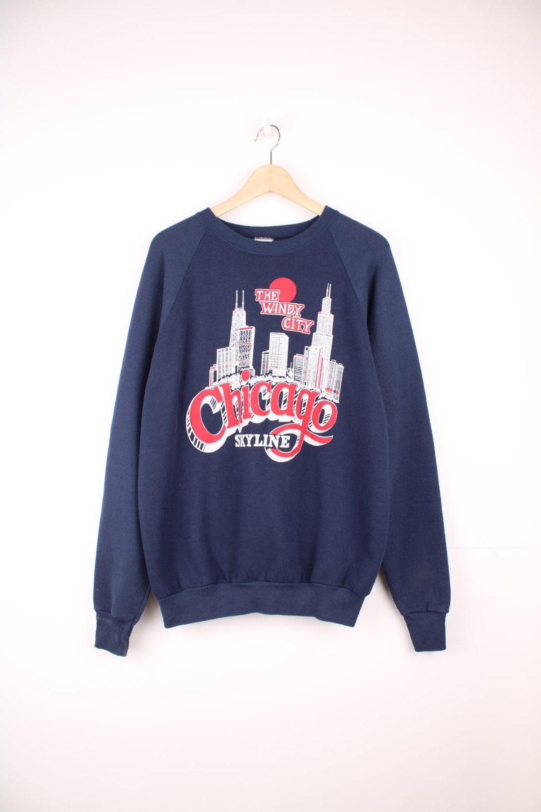 Navy blue spellout sweatshirt reading 'The Windy City, Chicago Skyline' with a city graphic in red and white. 