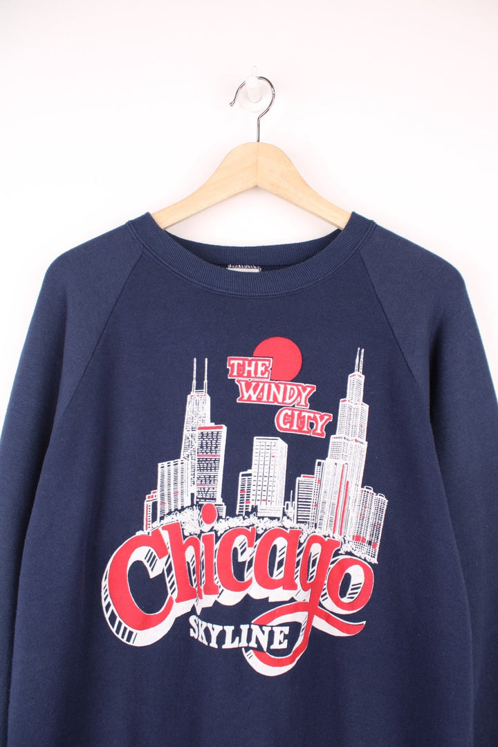 Navy blue spellout sweatshirt reading 'The Windy City, Chicago Skyline' with a city graphic in red and white. 