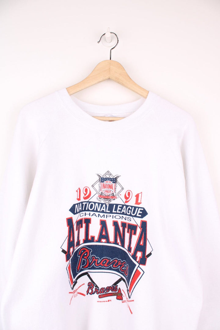 1991 Atlanta Braves sweatshirt in white with spellout reading '1991 National League Champions' and baseball designs in red and blue. 