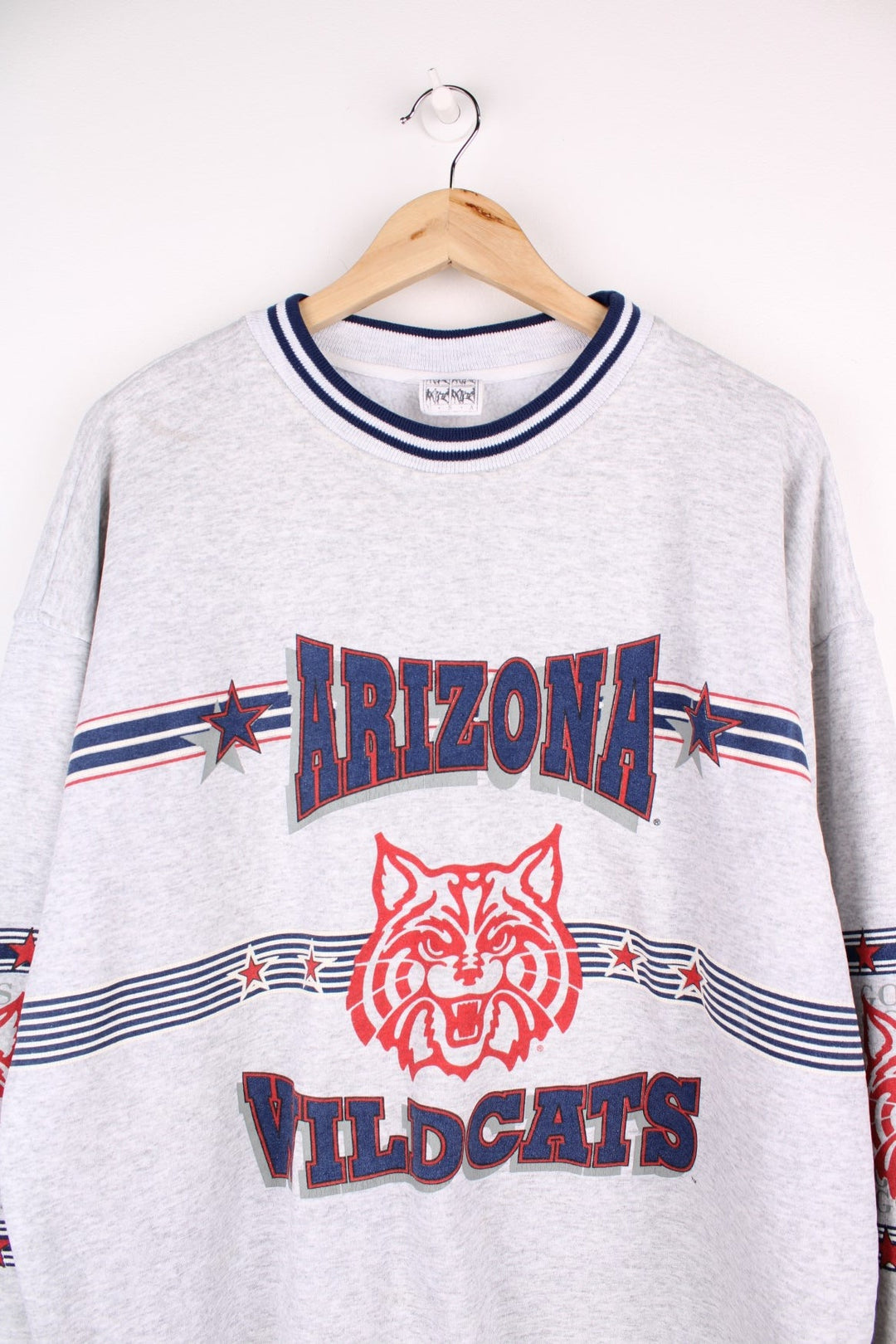  Vintage University of Arizona Wildcats Sweatshirt in grey marl with a printed logo across the chest and wrapping around sleeves.