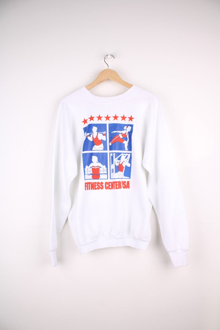  Fruit of the Loom 'Fitness Centre USA' Sweatshirt in white with a printed logo and red and blue sporty graphics on the front and across the back.