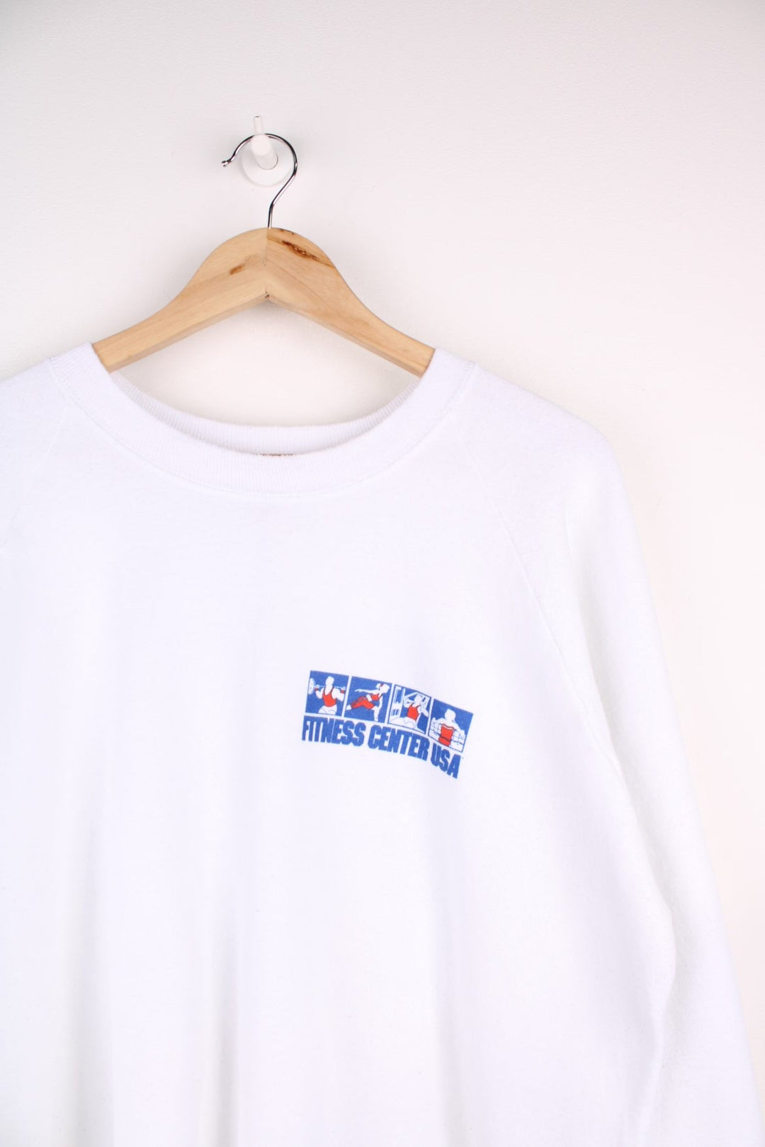  Fruit of the Loom 'Fitness Centre USA' Sweatshirt in white with a printed logo and red and blue sporty graphics on the front and across the back.