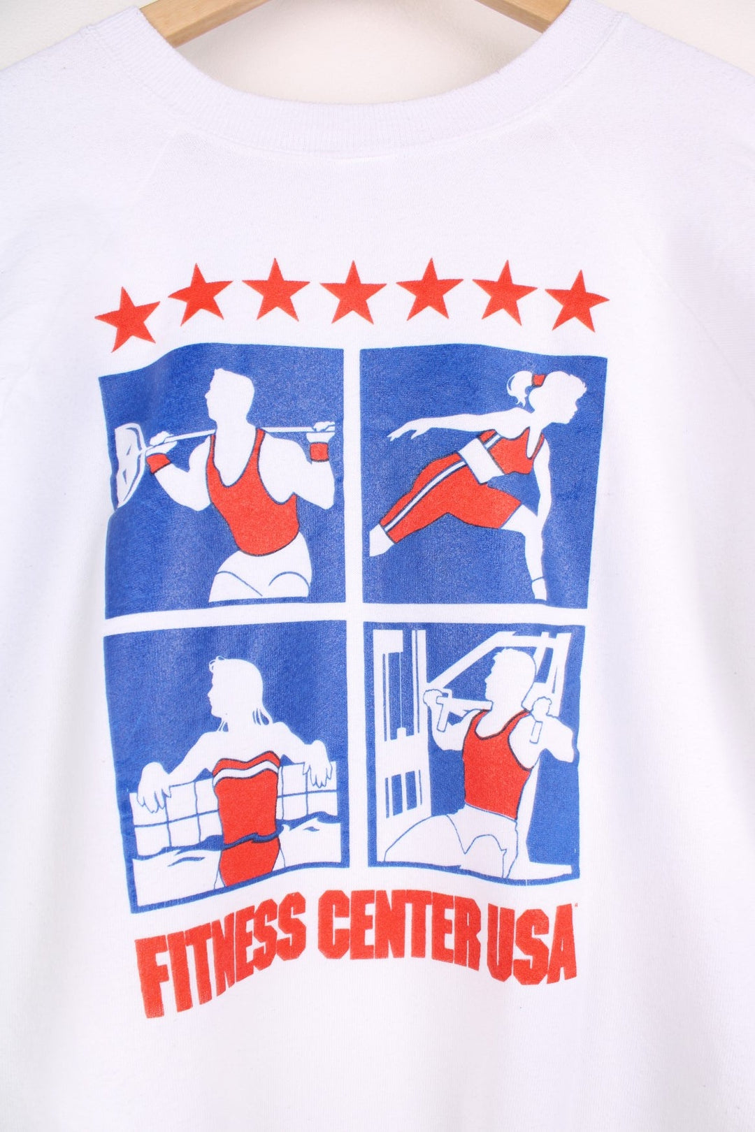  Fruit of the Loom 'Fitness Centre USA' Sweatshirt in white with a printed logo and red and blue sporty graphics on the front and across the back.