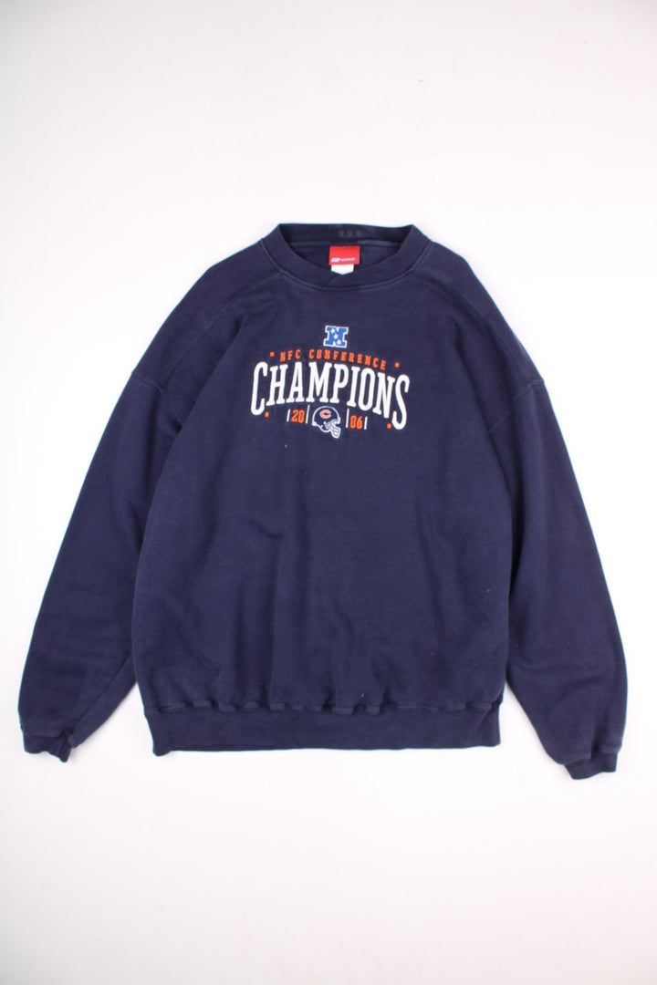 Vintage Reebok NFC Conference Sweatshirt in a navy blue colourway. The sweatshirt celebrates the success of 2006 NFC Champions - The Chicago Bears. The graphic on the front is embroidered and shows the team logo, and date of the conference. 