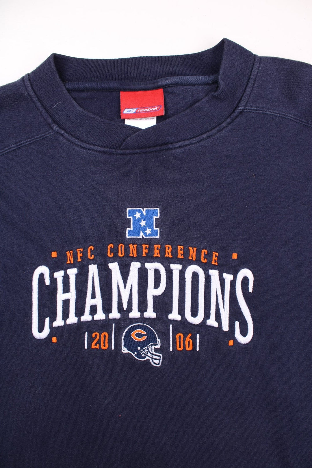 Vintage Reebok NFC Conference Sweatshirt in a navy blue colourway. The sweatshirt celebrates the success of 2006 NFC Champions - The Chicago Bears. The graphic on the front is embroidered and shows the team logo, and date of the conference. 