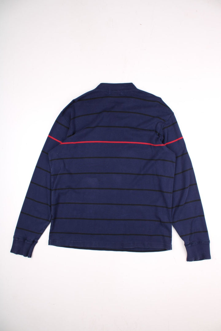 Vintage Ralph Lauren Polo Sport long sleeved Polo Shirt in a navy blue colourway with a small polo sport logo on the front, and red stripe running across the chest and arms. The shirt has a grandfather collar with two buttons to close. 