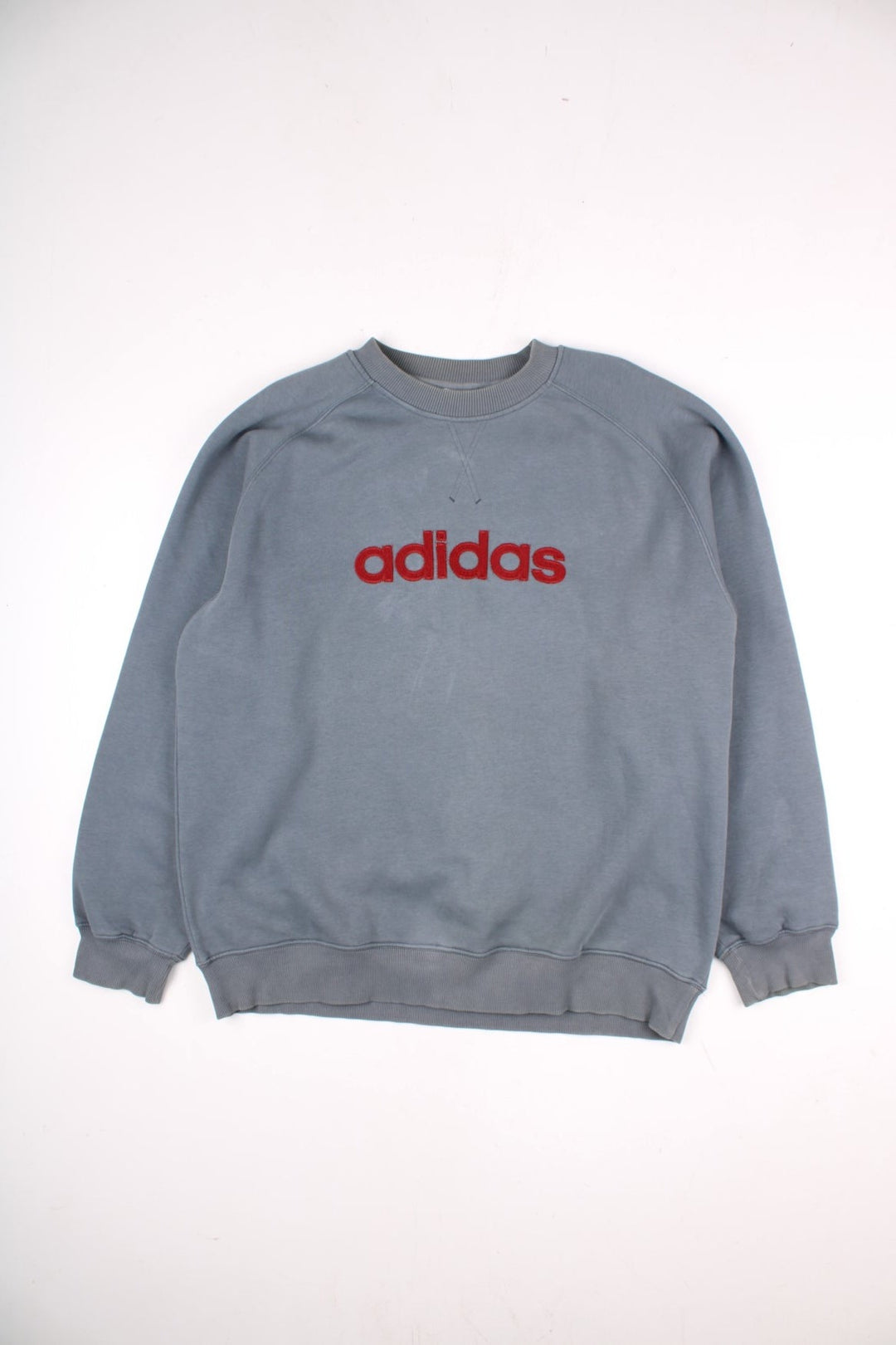 Vintage Adidas Sweatshirt in a grey colourway with the Adidas logo embroidered on the front. There is a small logo stitched onto the sleeve and a tag on the rear neck.